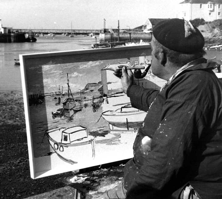 Black and white photo of painter painting on quayside
