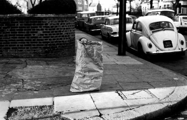 Girl playing in paper sack, West London