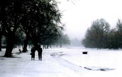 Couple by frozen lake, London, Regent's Park in snow